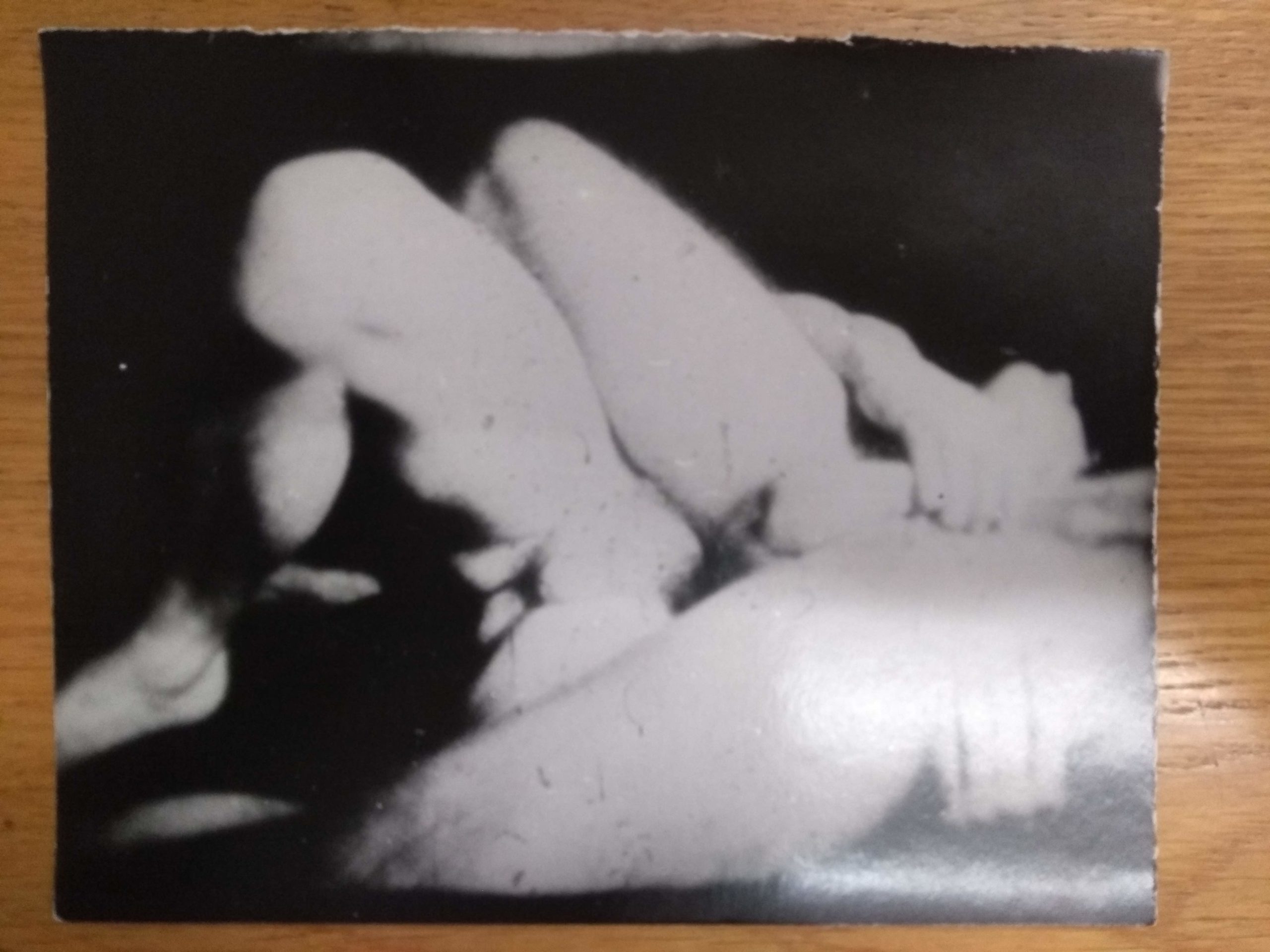 A B&W photograph of abstract body parts with a hint of foot and and hands. 