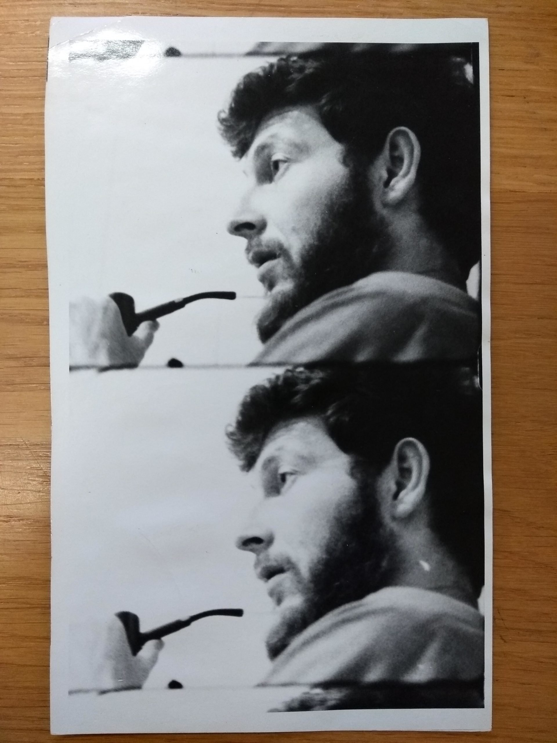 A B&W split-frame photograph of a white bearded man’s profile. He is holding a pipe close to his mouth. The same image in each frame. 