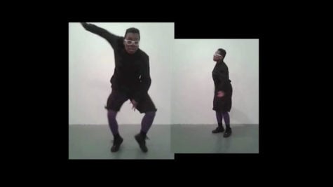 Two identical black people in white glasses and all black outfit. One on the left is dancing and the other on the right is staring at the person dancing. 