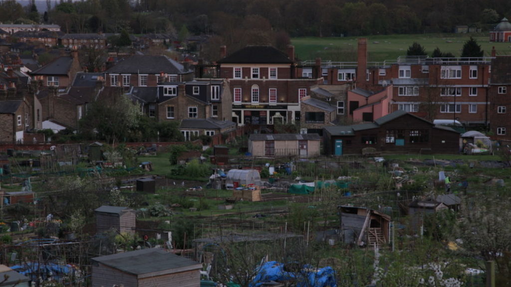 Against the backdrop of densely congregated brick houses a large portion of green space is sparse with small, very cheaply built housings.