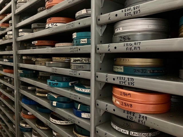 Film archive with shelves filled with stacks of film cans.