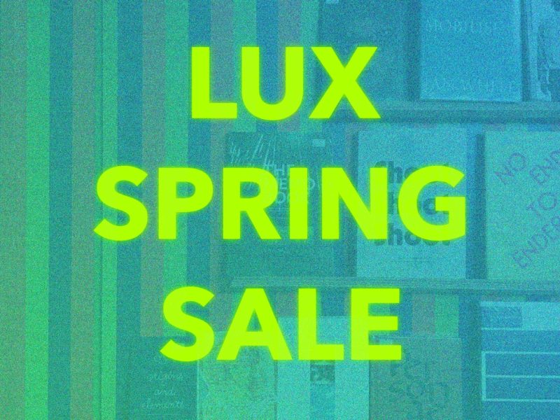 Large caption in yellow green reads “ LUX SPRING SALE” against a grainy blue tinted image of a stripe-patterned wall with a book display