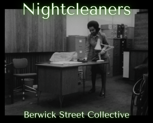 A black and white photograph of an office furnished with rows of paperwork cabinets. In the foreground stands a large wooden desk, behind which a person is wiping its surface with a cloth.