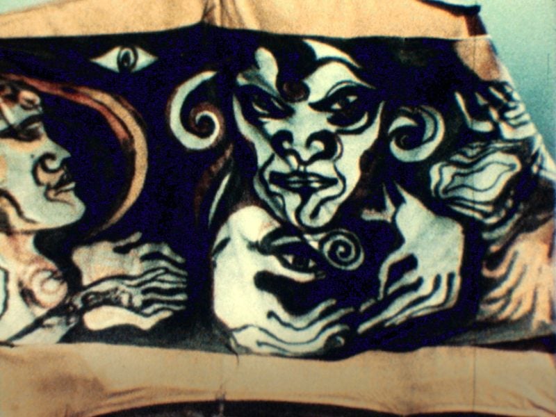 Fabric print featuring human figures set against a black background. The figures are defined by bold, curvaceous strokes, accentuating their eyes, hands, and facial contours