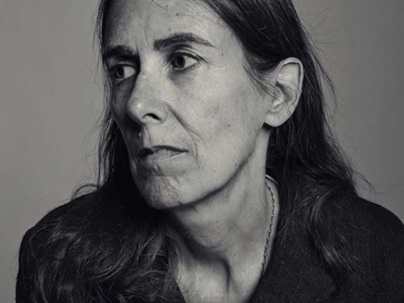 black and white portrait of a woman with a long hair and black top looking off the camera